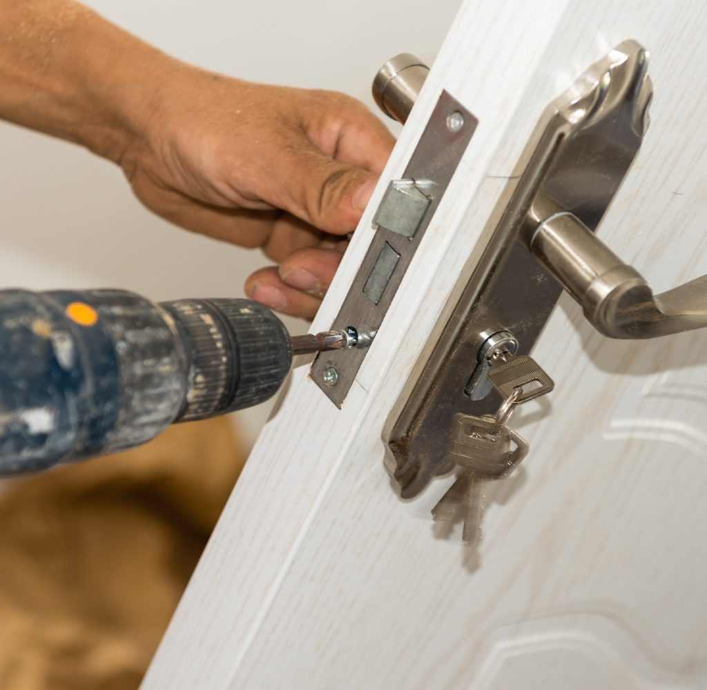 person installing deadbolt on door
