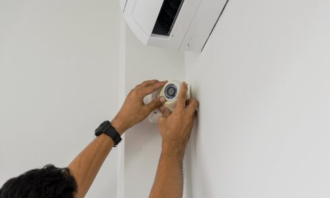 man installing home security system