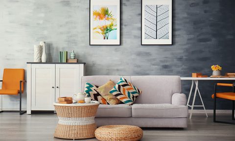 A living room with couch and artwork on the wall
