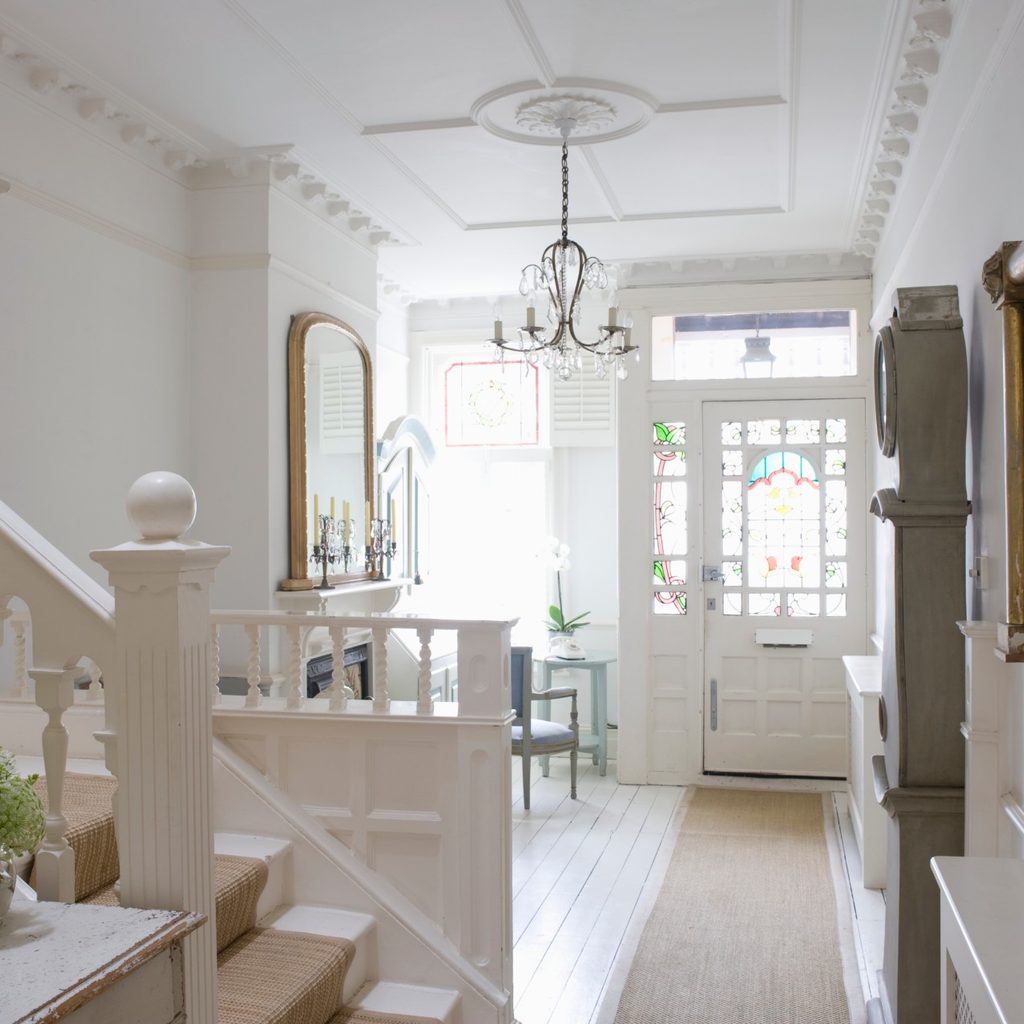 Sunny home with front door, rug and stairs