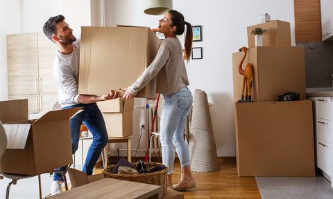 Man and woman moving big box in house