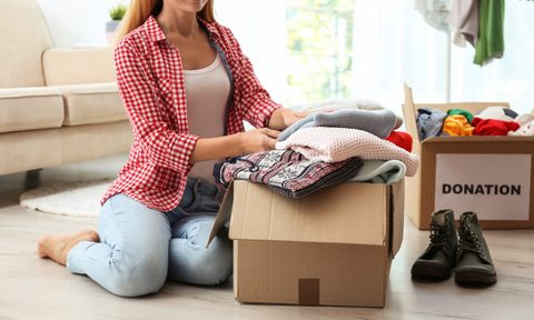 Woman placing clothes in donation boxes
