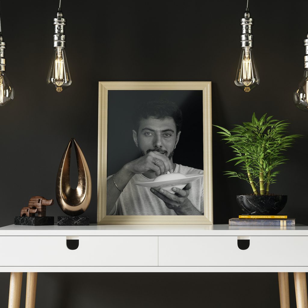 portrait photo in a wooden frame on top of a white dresser
