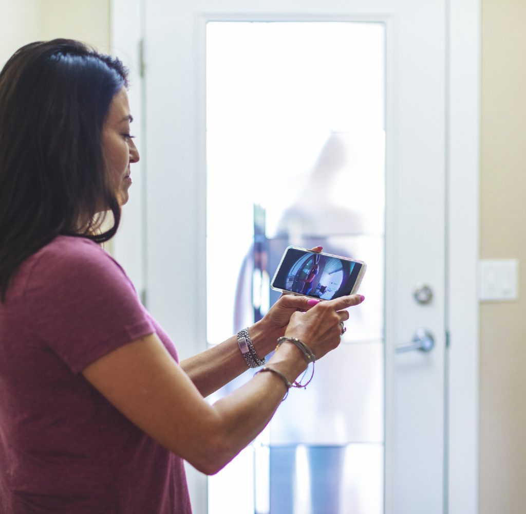 woman using smart doorbell