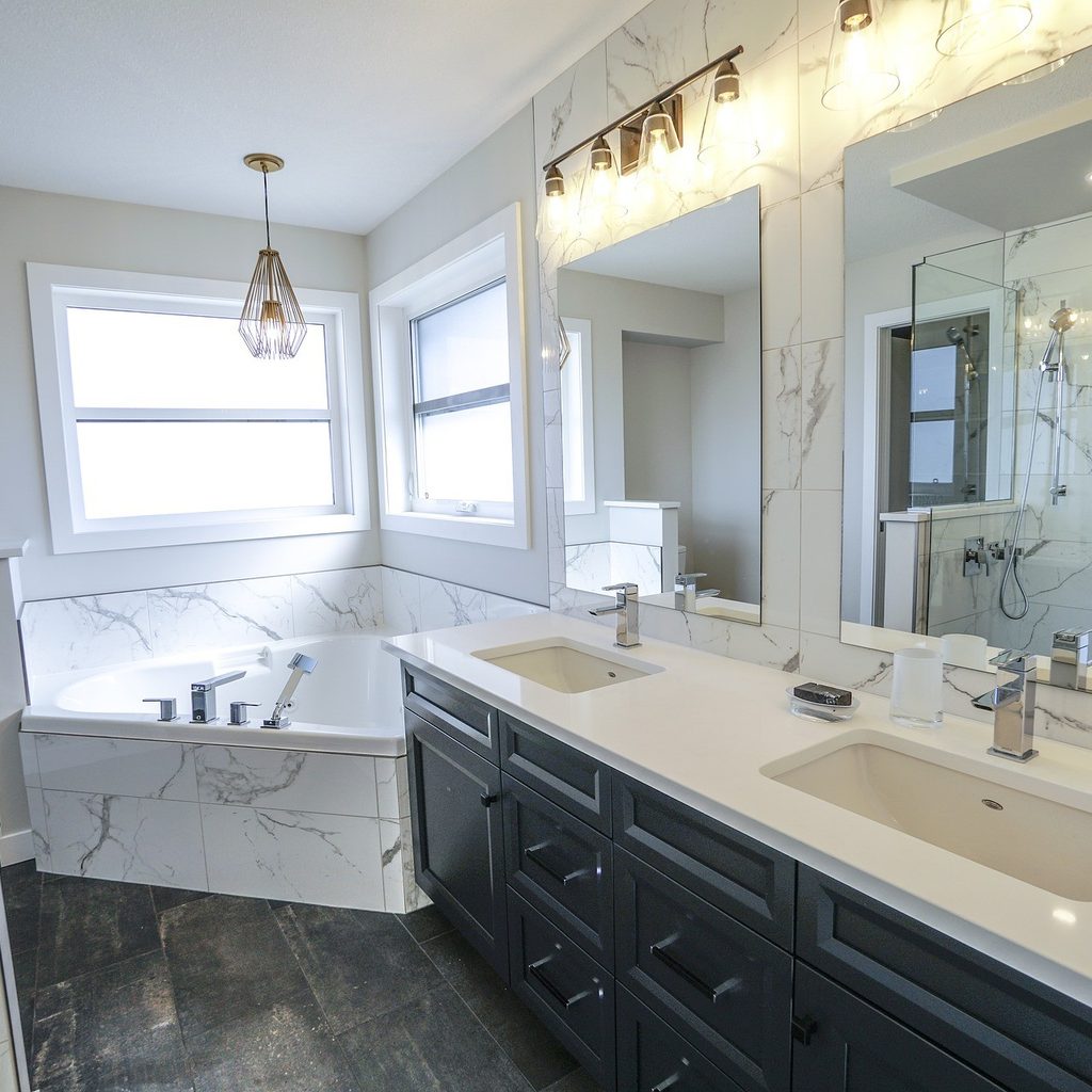 Bathroom with large sink, bathtub, and chandelier