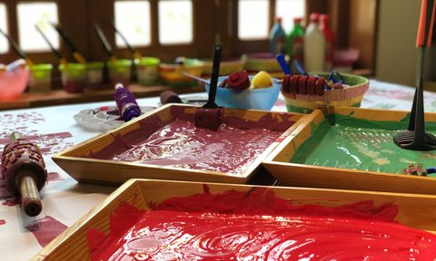 Three paint trayswith paint colors of red, green, and burgundy in them