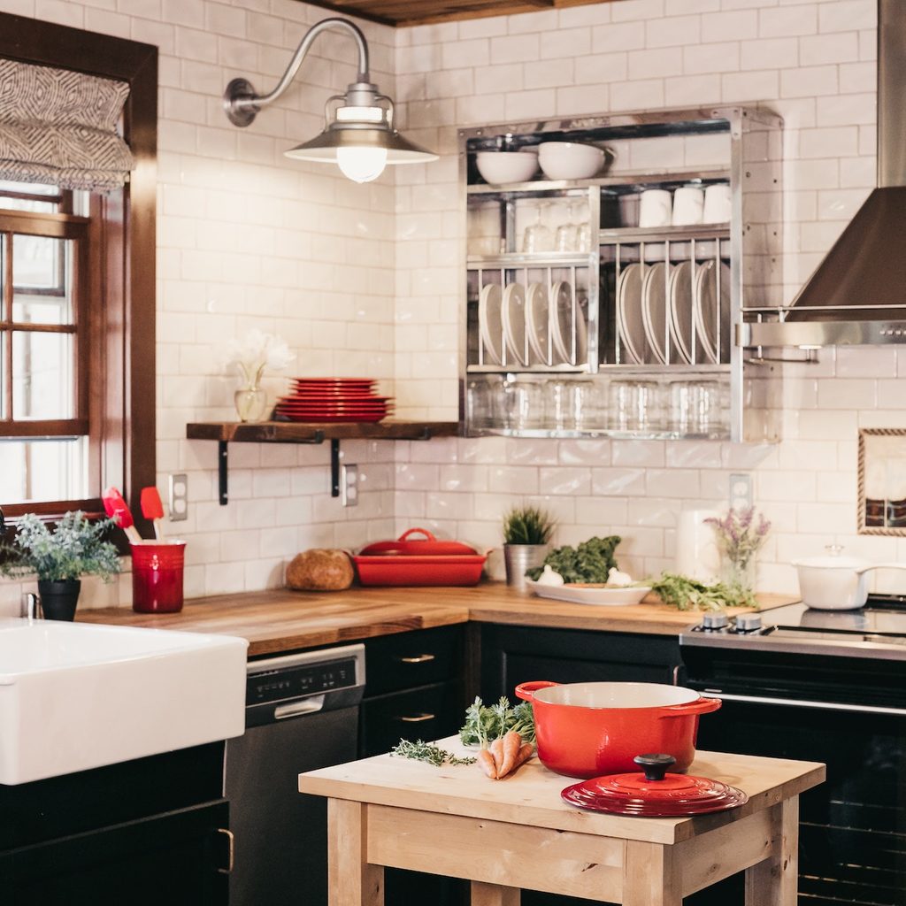 kitchen area with counter, island and stove and red items throughout
