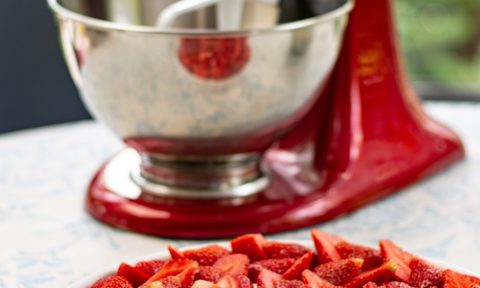 Red stand mixer with strawberries