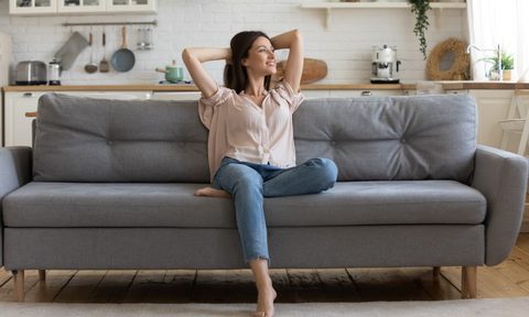 Woman sitting on a couch in a clean home