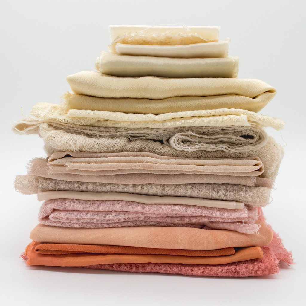 stack of different fabrics in various light colors