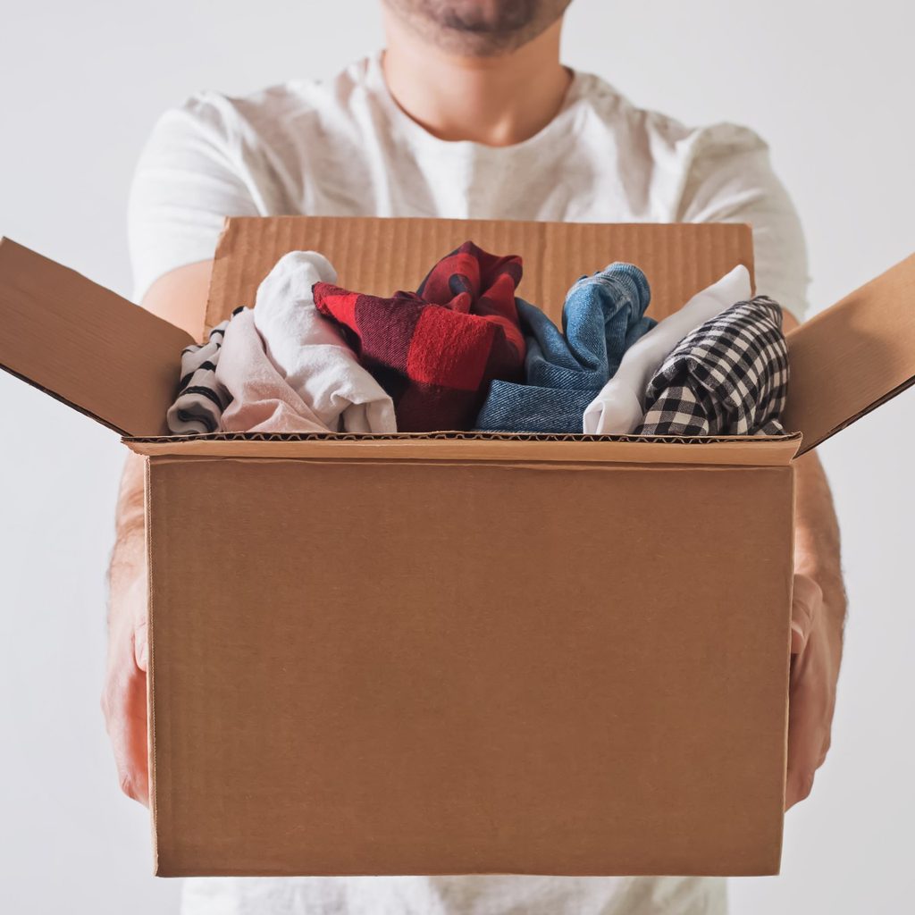 Man holding box of folded clothes