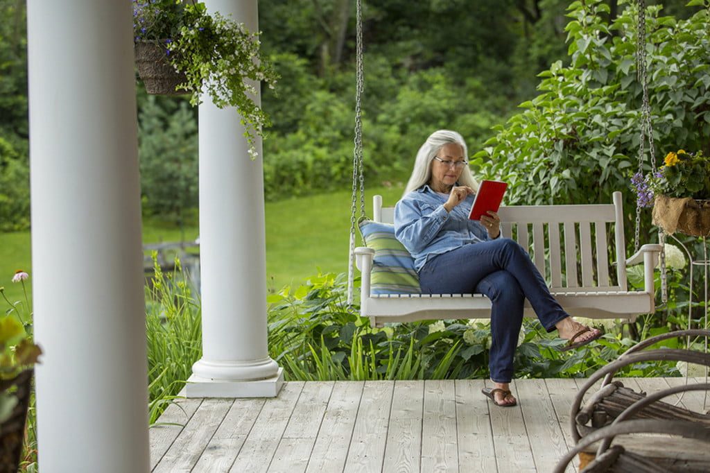 Woman reading on a front porch swing