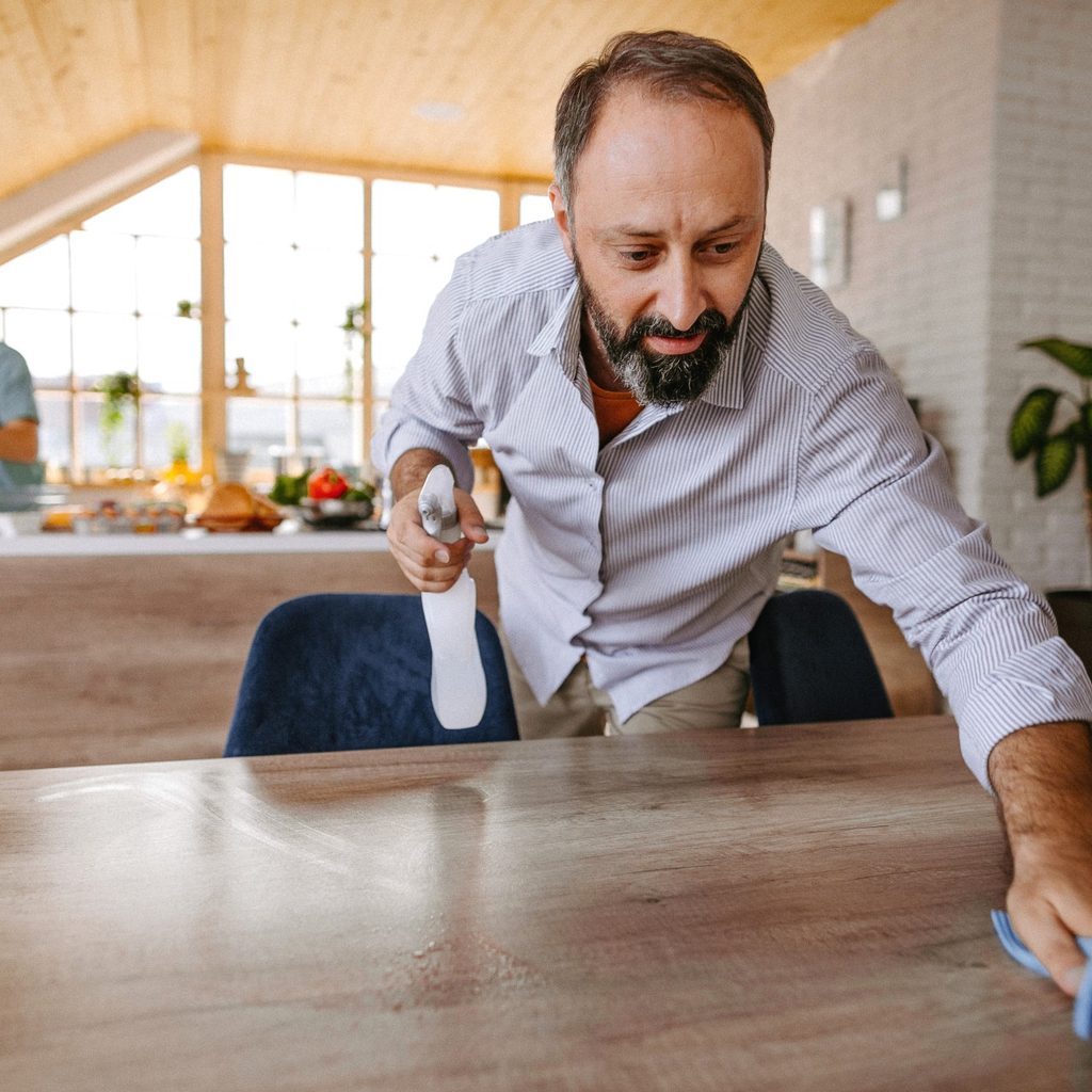 Man cleaning home with a spray bottle