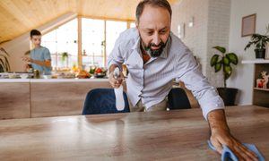 Man cleaning home with a spray bottle