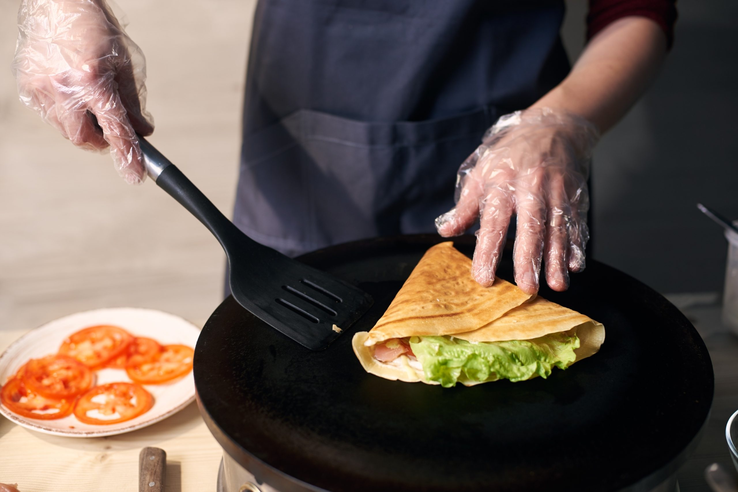 person cooking tortilla on portable cooktop