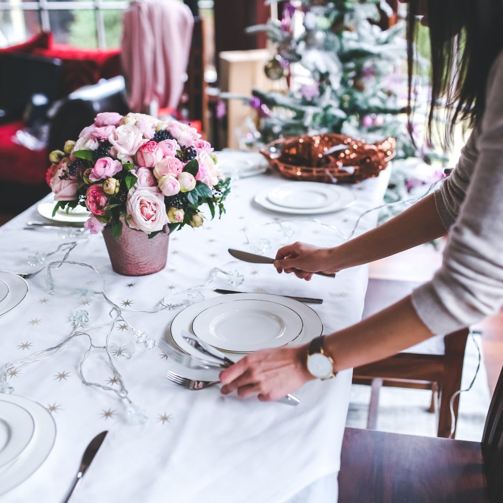 Woman setting dinner table for christmas party