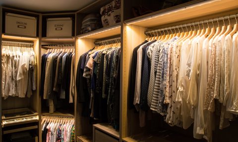 rows of clothes in a closet with lighting