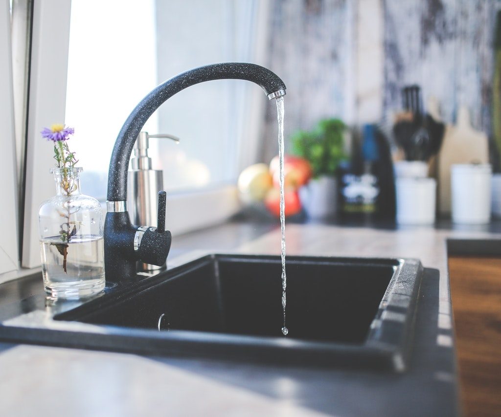 Black kitchen faucet with water running