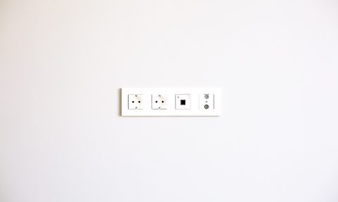 White wall with white strip of electrical outlets