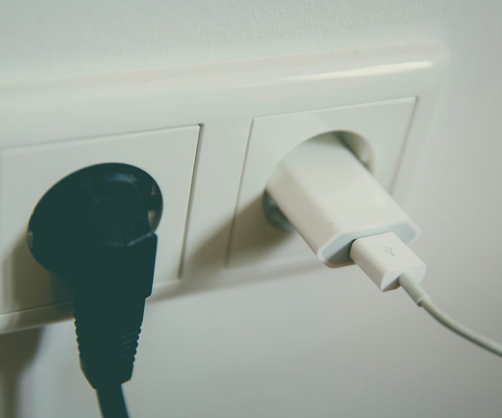 Black and white plugs in electrical outlet