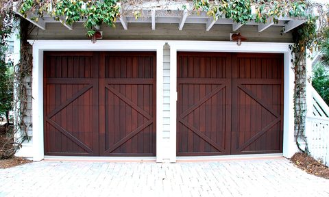 Cherry-colored double garage doors with ivy above