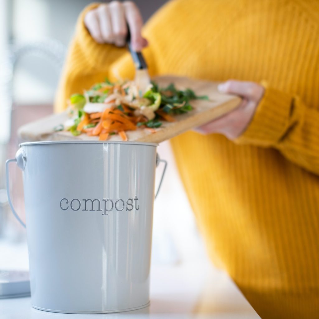 Woman putting items into a compost container