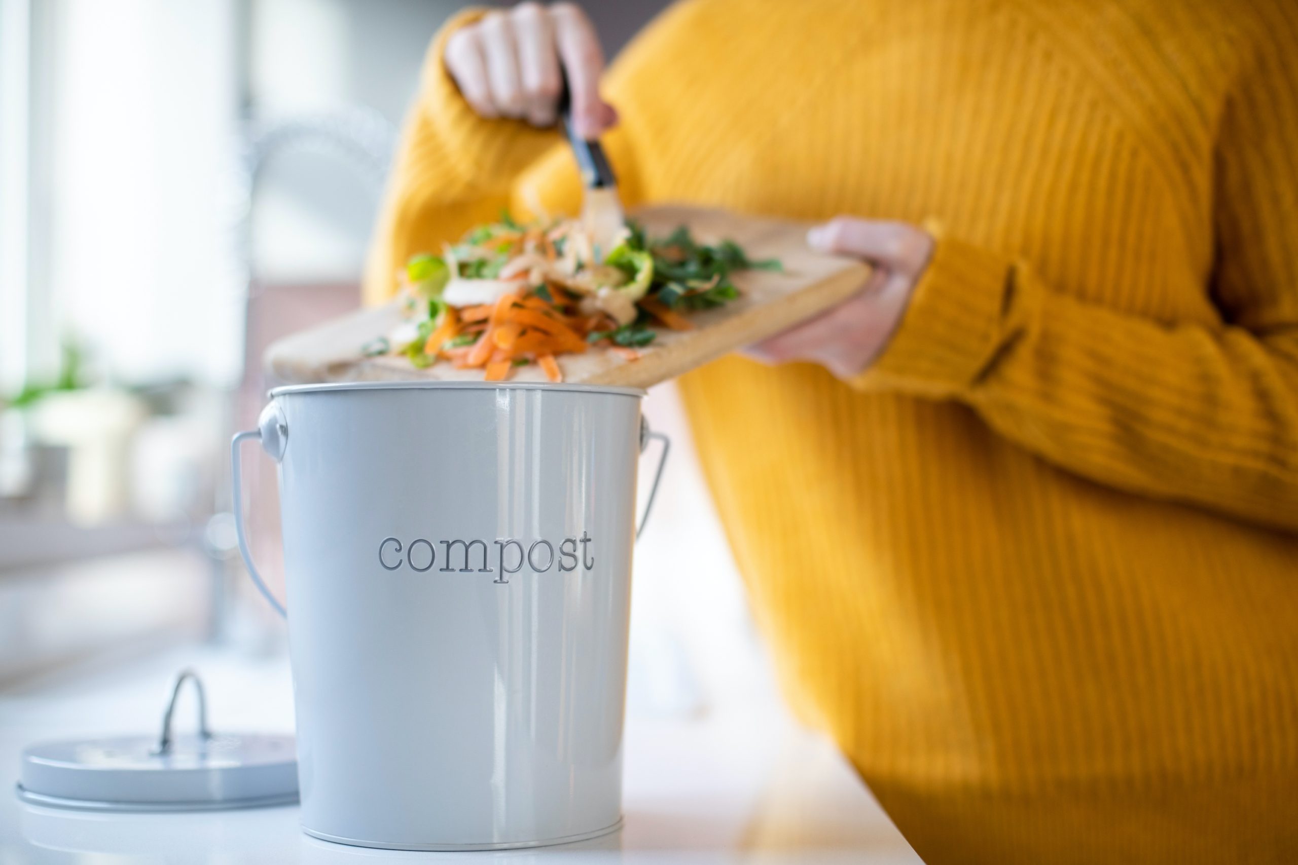 Woman putting items into a compost container