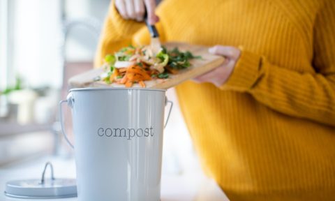 Woman putting items into a compost container