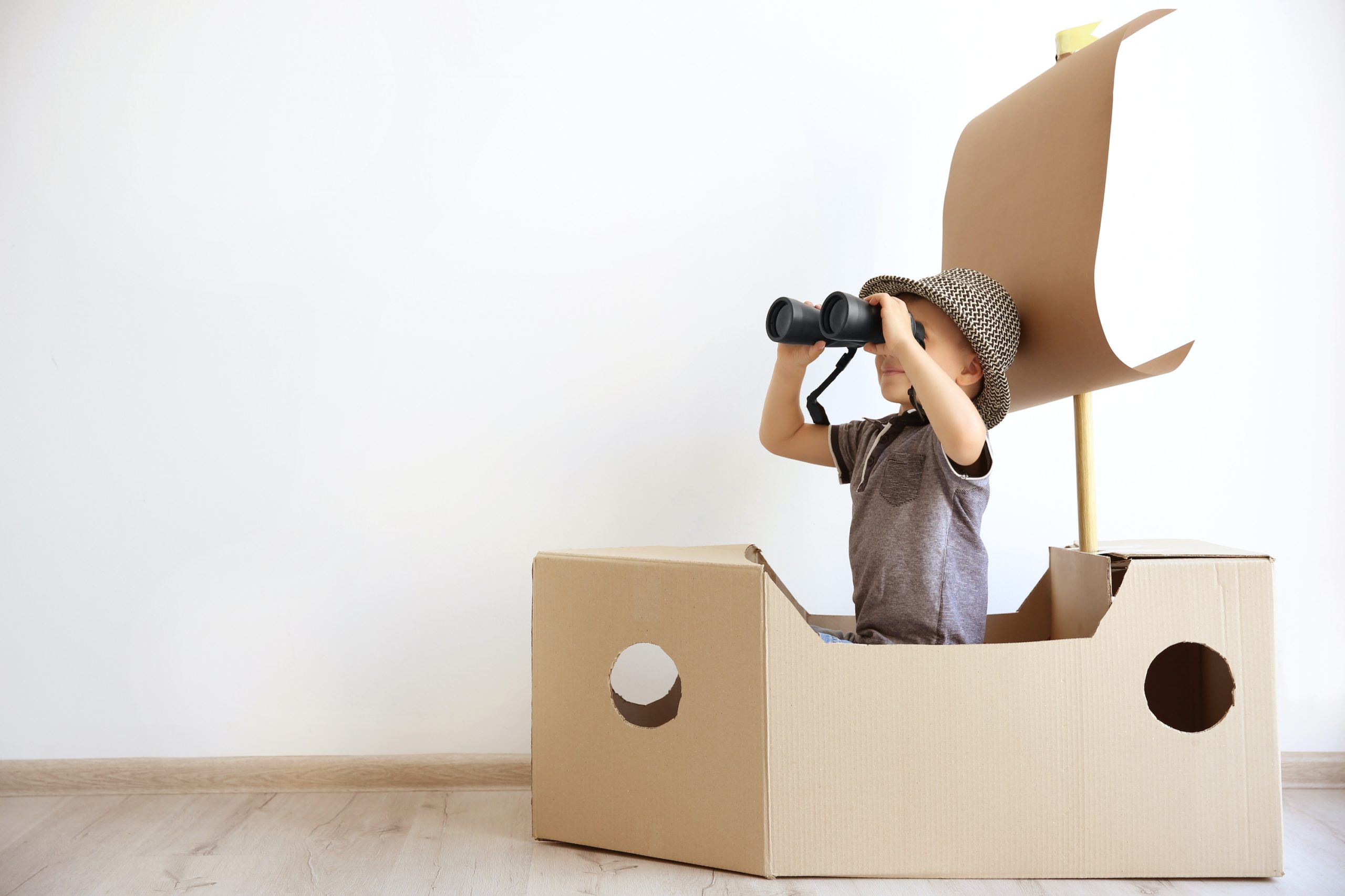 Child playing in a cardboard box