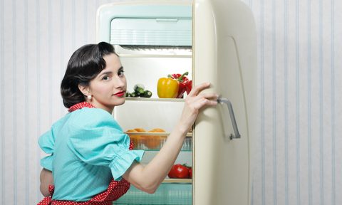 woman in 50s garb in front of vintage refrigerator