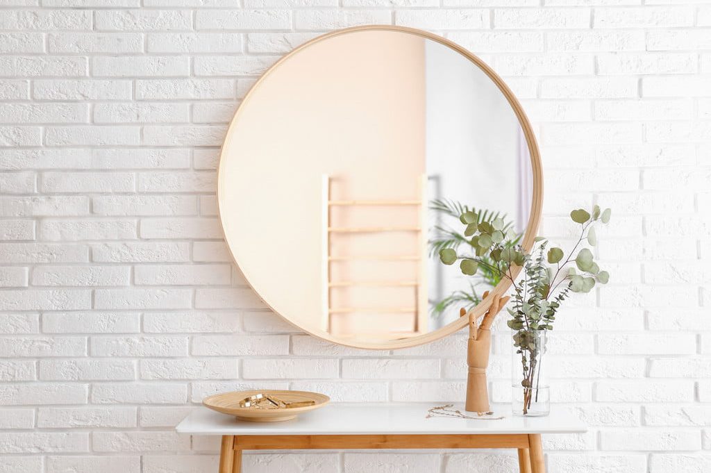 round circle mirror above console table