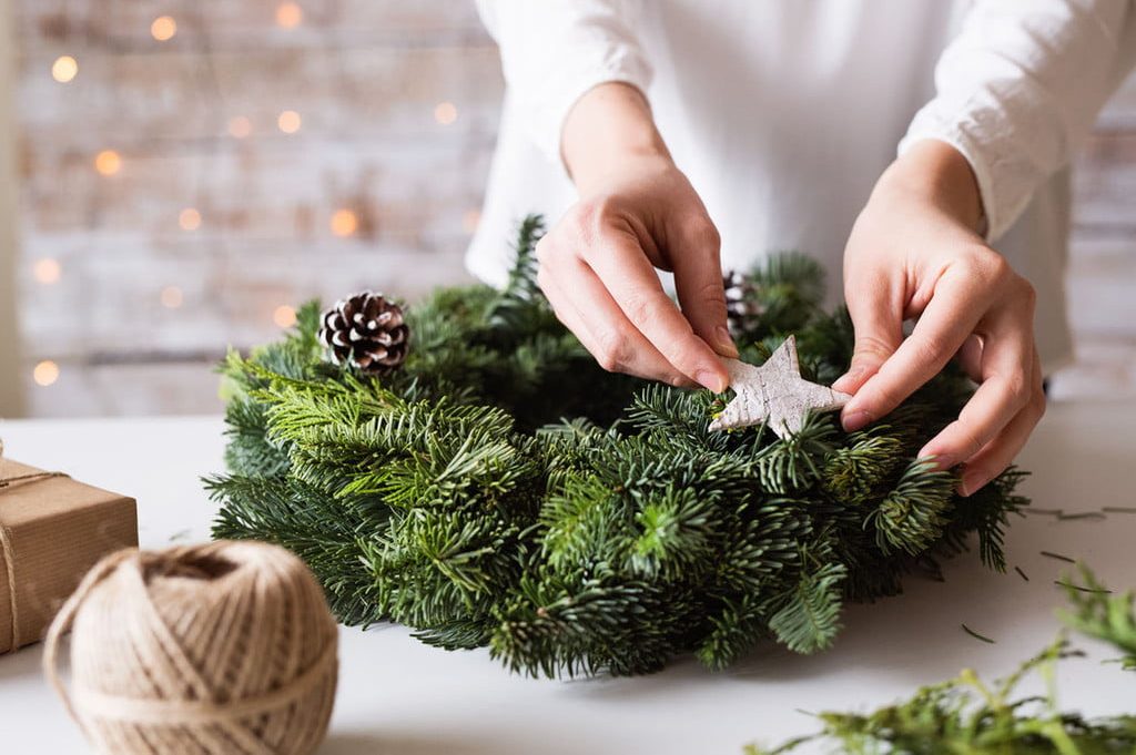 person decorating christmas wreath
