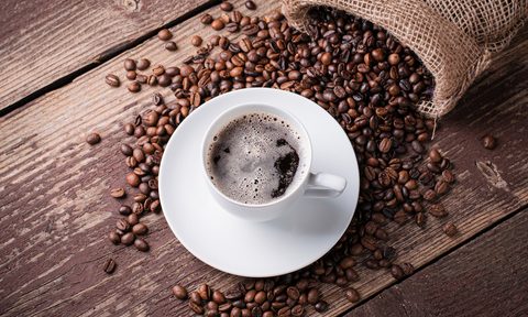 Cup of coffee on a pile of coffee beans