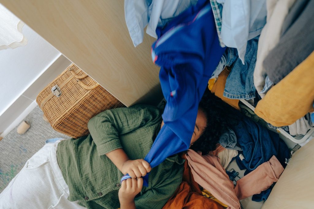 Young woman pulling clothes in a closet