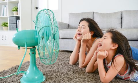 mother and daughter cooling down with fan