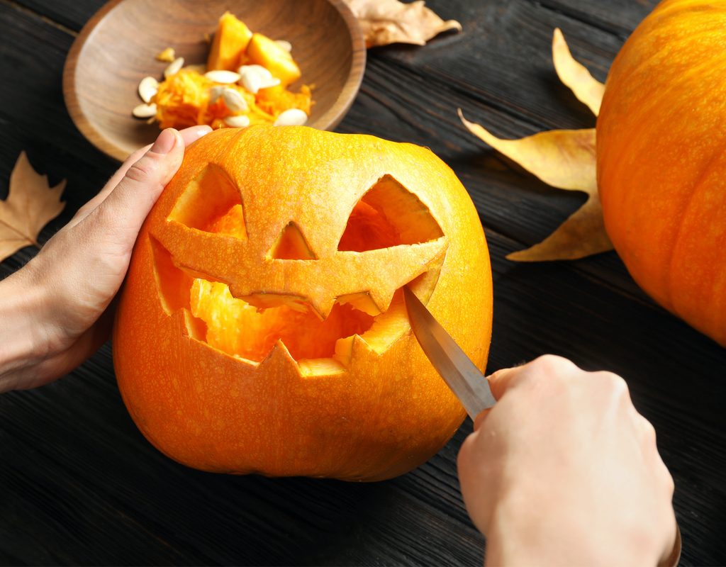 Person carving jack-o'-lantern