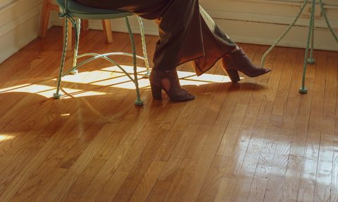 hardwood floor closeup with person in chair