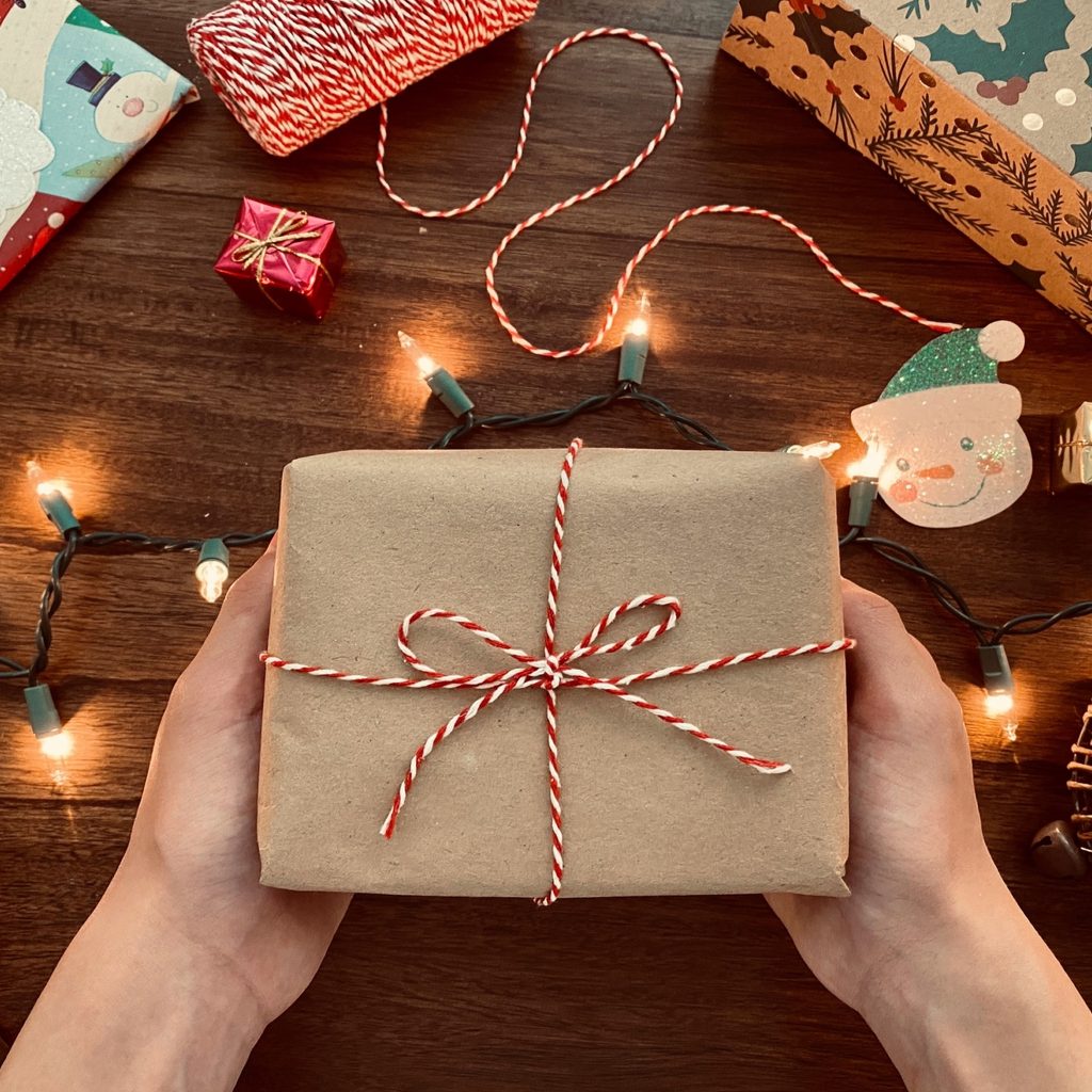 Person holding small wrapped gift.