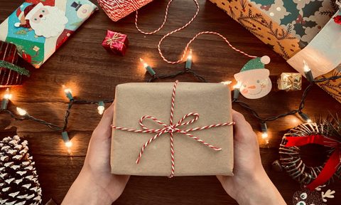 Person holding small wrapped gift.