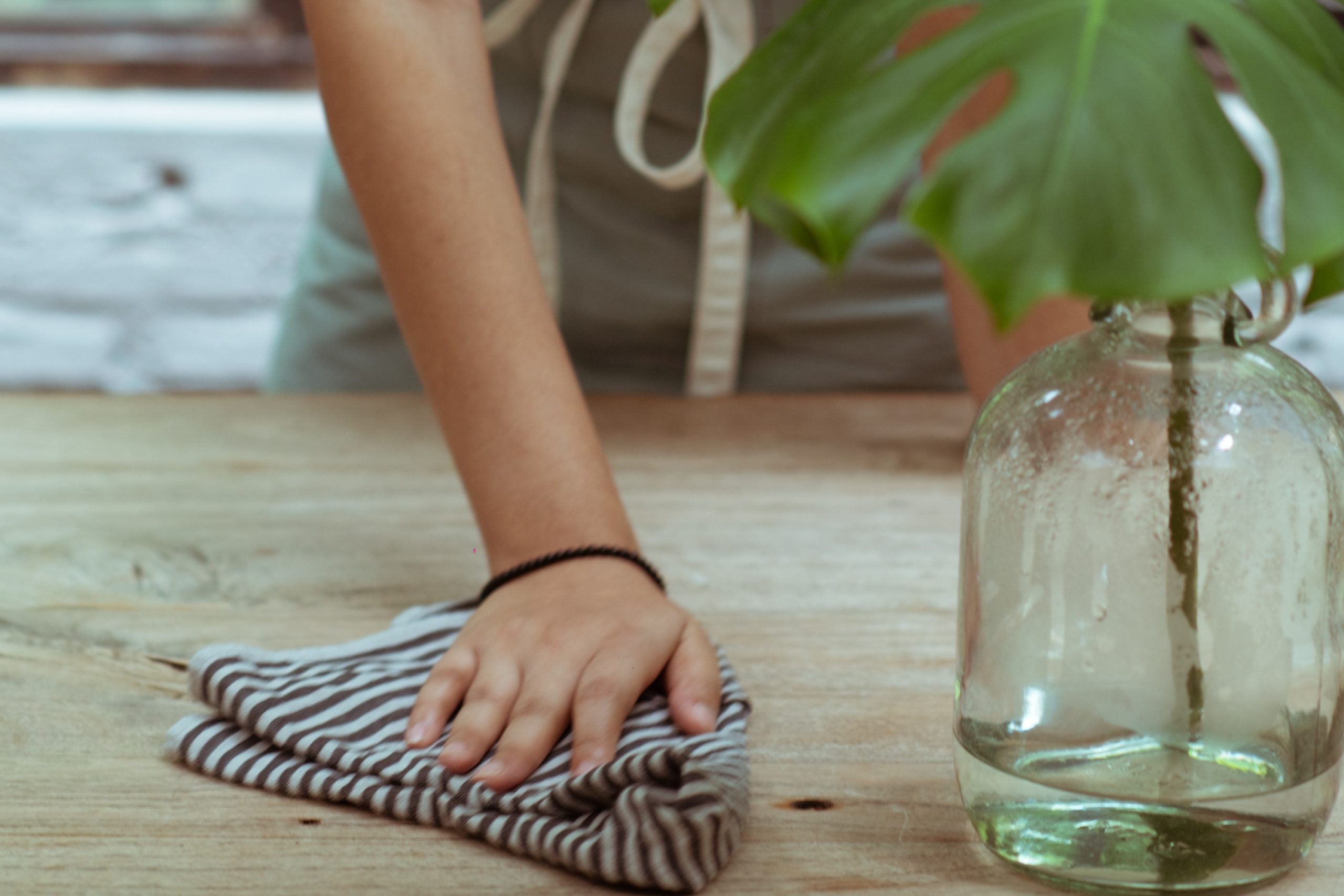 Person using cloth to wipe a table
