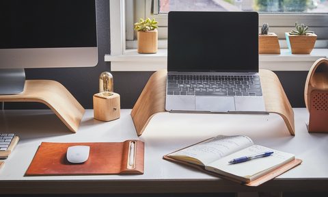 Home office desktop with laptop and notepad
