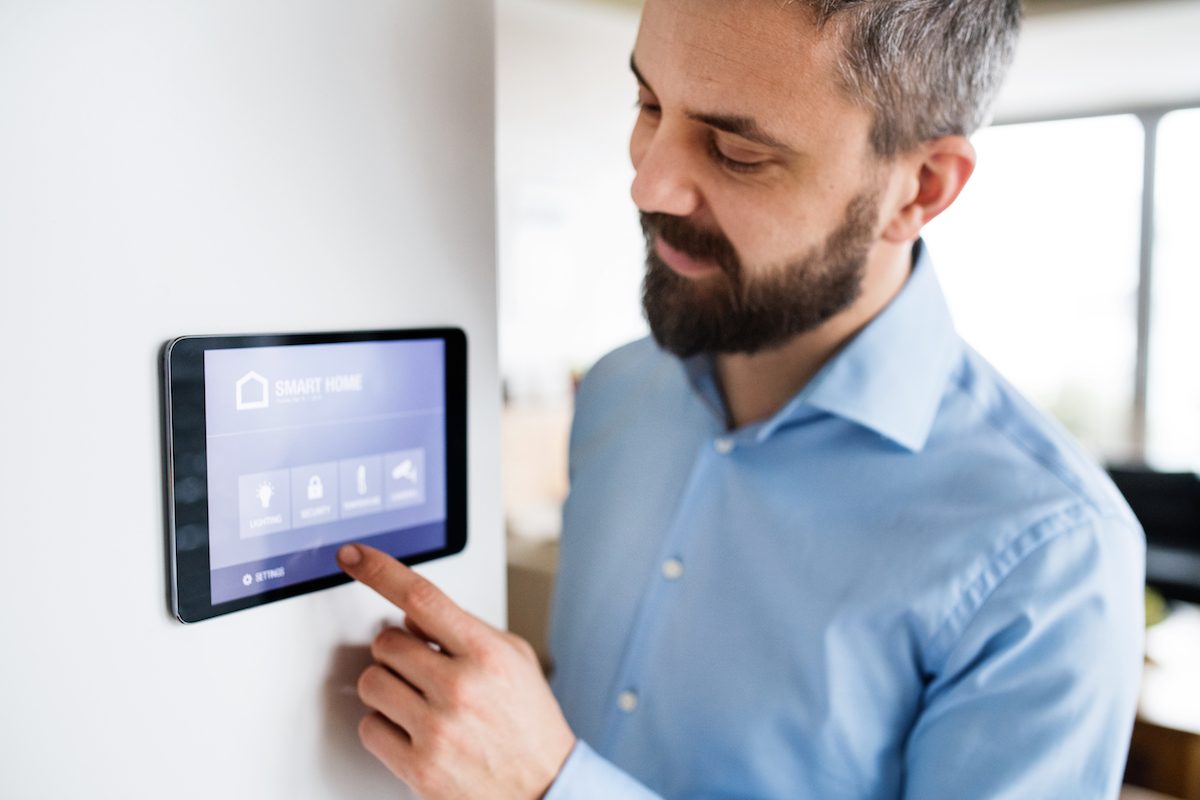 Man setting smart thermostat