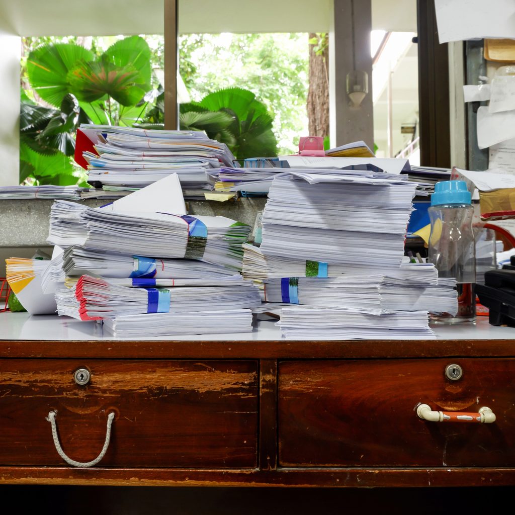 Office desk with paper clutter on top
