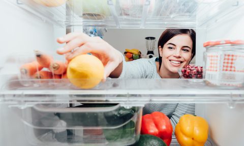 Woman opening fridge to get fruit
