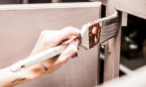 Closeup of hand painting kitchen cabinet