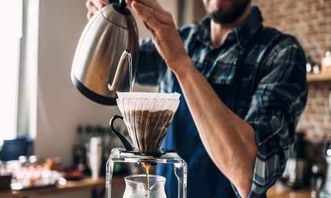 Person using pour-over coffee maker