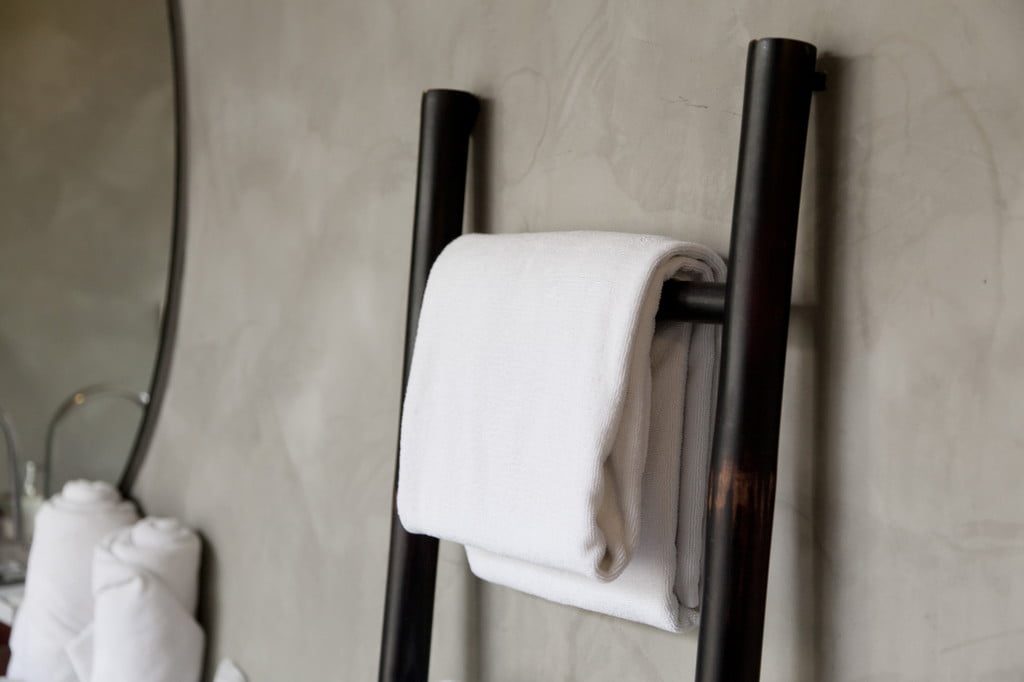 white towel hanging on bathroom towel ladder