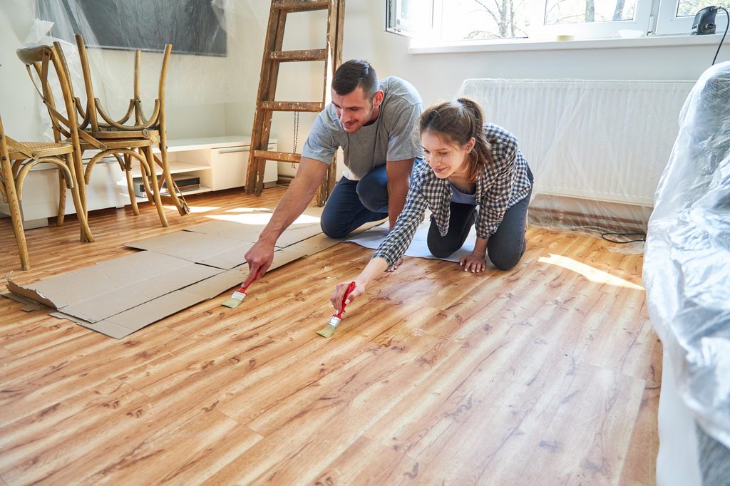 Couple staining a wood floor