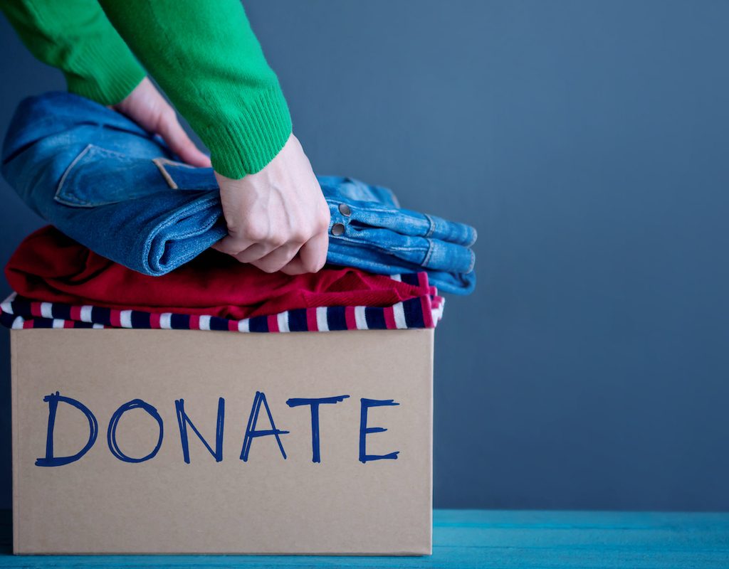 Person putting clothing into a donate box