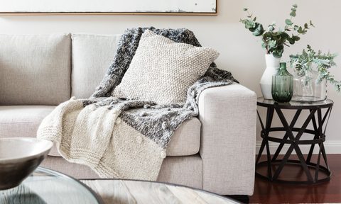 neutral couch with textured pillow and throw